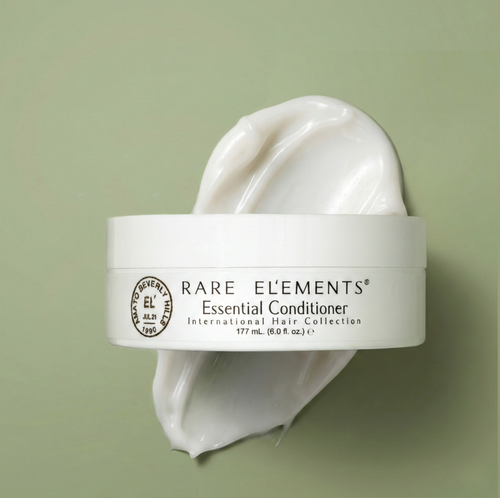 Rare Elements Essential Conditioner jar with a scoop of product on a green background