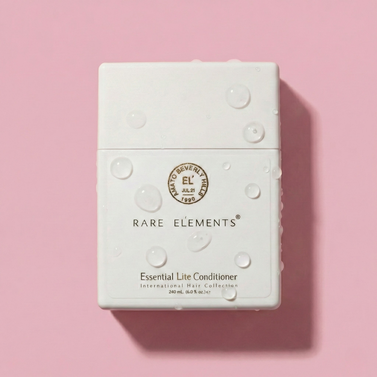 White conditioner bottle with 'Rare Elements Essential Conditioner on a pink background